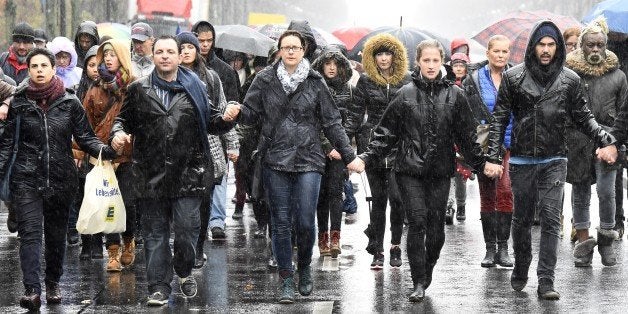 People take part in a memorial march in Berlin, on November 15, 2015 for the victims of the deadly attacks in and around Paris on November 13. Germany's interior minister made a plea against linking the terror attacks in Paris to the record influx of asylum seekers into Europe. AFP PHOTO / TOBIAS SCHWARZ (Photo credit should read TOBIAS SCHWARZ/AFP/Getty Images)