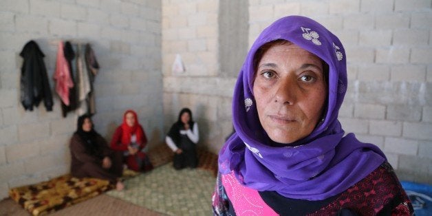 HATAY, TURKEY - NOVEMBER 21: A Syrian refugee woman fled from her home due to civil war is seen at a house in Reyhanli district of Hatay on November 21, 2015. Syrian refugee families who fled their country due to the ongoing civil war try to hold on to life as they live in rented houses, tents and storehouses. (Photo by Cem Genco/Anadolu Agency/Getty Images)