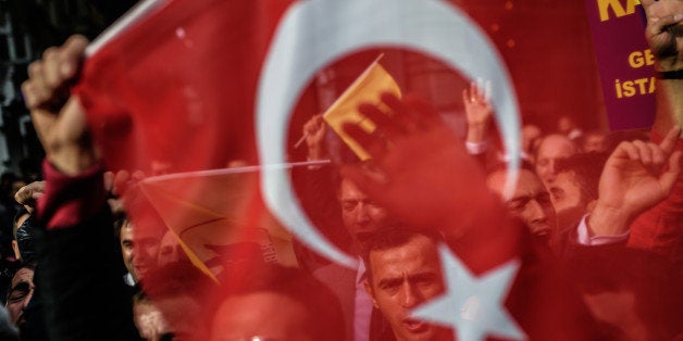 A protester waves Turkey's national flag as he and others shout slogans in front of the Russian Istanbul consulate during a demonstration against Russia's Syria policy on November 24, 2015 in Istanbul. NATO member Turkey on Tuesday shot down a Russian fighter jet on the Syrian border, threatening a major spike in tensions between two key protagonists in the four-year Syria civil war. AFP PHOTO/OZAN KOSE / AFP / OZAN KOSE (Photo credit should read OZAN KOSE/AFP/Getty Images)