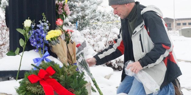 COLORADO SPRINGS, CO - NOVEMBER 28: Roy Kieffer lays flowers on a memorial at Fillmore Street and Centennial Boulevard on November 28, 2015 in Colorado Springs, Colorado. Life in Colorado Springs attempts to go back to normal after the shooting that killed three people including one police officer that ended at a Planned Parenthood. Stores in the strip mall across from the Planned Parenthood have begun to reopen. (Photo by Brent Lewis/The Denver Post via Getty Images)