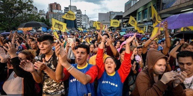 Supporters cheer during a Movement of Democratic Unity (MUD) opposition party's rally, in Caracas on December 2 , 2015. Sixteen years into late president Hugo Chavez's leftist 'revolution,' opinion polls indicate the opposition is poised to win legislative elections Sunday for the first time since the firebrand leader came to power. AFP PHOTO/FEDERICO PARRA / AFP / FEDERICO PARRA (Photo credit should read FEDERICO PARRA/AFP/Getty Images)