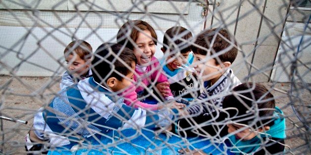 In this Saturday, Nov. 28, 2015 photo, Syrian refugee children play at a temporary refugee camp in Irbil, northern Iraq. Some
