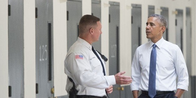 US President Barack Obama, alongside Ronald Warlick (L), a correctional officer, tours a cell block at the El Reno Federal Co