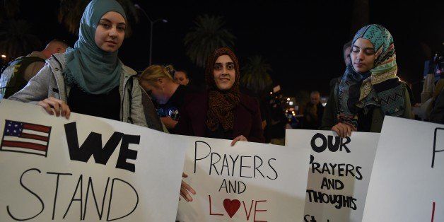 Samar Natori (L), from Redlands, CA, with family and friends who are all Muslims arrive at a candlelight vigil at the San Manuel Stadium in San Bernardino, California, December 3, 2015. Vigils were held all around the region to mourn the 14 victims of the previous day's mass shooting in San Bernardino. AFP PHOTO / ROBYN BECK / AFP / ROBYN BECK (Photo credit should read ROBYN BECK/AFP/Getty Images)
