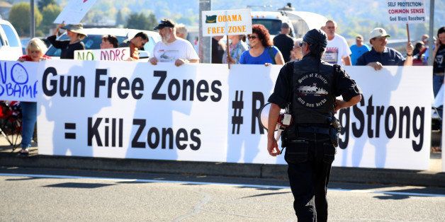 FILE - In this Oct. 9, 2015 file photo, demonstrators wait outside of Roseburg Regional Airport for President Barack Obama's arrival in Roseburg, Ore. Voters in a southern Oregon county will weigh in next month on a measure that seeks to prohibit enforcement of gun laws, although it may have only symbolic effect. (AP Photo/Ryan Kang, File)