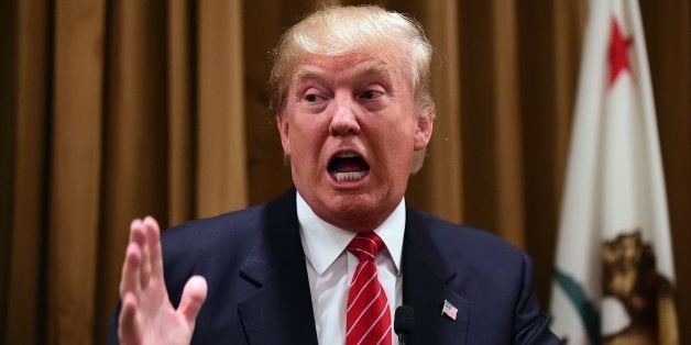 Donald Trump gestures at a press briefing where he introduced people whose families were victims of illegal immigrants on Jul