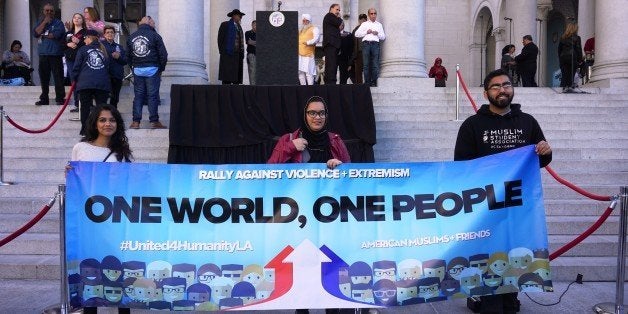 LOS ANGELES, UNITED STATES - DECEMBER 13: Protesters hold a banner written 'One world, one people' on it as hundreds of Californians, mostly including Muslims, gathered during a protest against terrorism and violence, staged with the attendance of Los Angeles Mayor Eric Garcetti (not seen), San Bernardino Mayor Carey Davis (not seen) and Chief of the Los Angeles Police Department Charlie Beck (not seen) with some prominent Muslims of the society, in front of the Los Angeles City Hall on December 13, 2015 in Los Angeles, CA, USA. (Photo by Mintaha Neslihan Eroglu/Anadolu Agency/Getty Images)