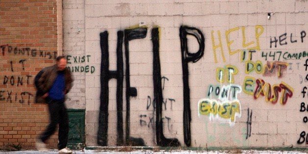 A pedestrian walks by a graffiti marked wall in west Detroit on Thursday, Dec. 11, 2008. The roots of Detroit's current plight go back decades. Court-ordered school busing and the 12th Street riots of 1967 accelerated an exodus of whites to the suburbs, and many middle-class blacks followed, shrinking the city's population from a peak of 1.8 million in the 1950s to half that now.(AP Photo/Carlos Osorio)