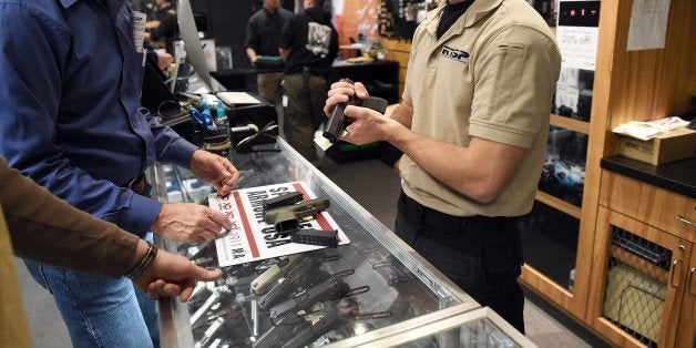 An employee shows handguns to customers at the RTSP shooting range in Randolph, New Jersey on December 9, 2015. US President Barack Obama called for tougher gun controls in the wake of the California shootings, starting with a ban on gun purchases for anyone on a US government no-fly list. AFP PHOTO/JEWEL SAMAD / AFP / JEWEL SAMAD (Photo credit should read JEWEL SAMAD/AFP/Getty Images)