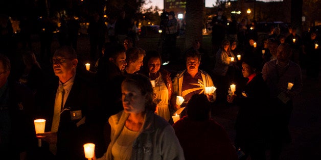 SAN BERNARDINO, CA - DECEMBER 7: People listen during a candlelight vigil held at the San Bernardino County Board of Supervisors headquarters in San Bernardino, CA on Monday, December 07, 2015. A heavily armed man and woman opened fire Wednesday on a holiday banquet for his co-workers, killing multiple people and seriously wounding others in a precision assault, authorities said. Hours later, they died in a shootout with police. (Photo by Jabin Botsford/The Washington Post via Getty Images)