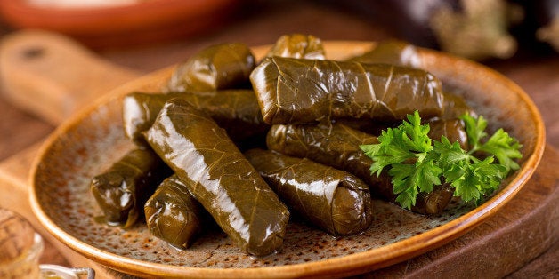 A plate of delicious stuffed grape leaves with parsley garnish.