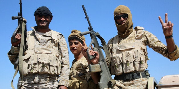 Armed Yemeni tribesmen from the Popular Resistance Committees, supporting forces loyal to Yemen's Saudi-backed President Abedrabbo Mansour Hadi, flash the sign of victory as they hold a position in the area of Sirwah, west of Marib city, on December 18, 2015. A Yemen ceasefire appeared to have collapsed as government forces captured two towns from rebels and an allied Arab coalition accused insurgents of escalating the conflict by firing ballistic missiles. AFP PHOTO / ABDULLAH AL-QADRY / AFP / ABDULLAH AL-QADRY (Photo credit should read ABDULLAH AL-QADRY/AFP/Getty Images)