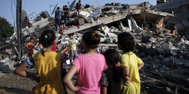 Palestinians look at a house that was destroyed by an Israeli air strike in Gaza City on August 23, 2014. A powerful Israeli air strike leveled the house, of a family that included members of Hamas, late Friday, after a drone fired two rockets at the two-story property before an F16 warplane dropped a bomb, according to witnesses. Israel kept up the pressure on Hamas in Gaza, carrying out multiple air strikes that killed six Palestinians, five of them from the same family, as Egypt readied to call new truce talks. AFP PHOTO/ THOMAS COEX (Photo credit should read THOMAS COEX/AFP/Getty Images)