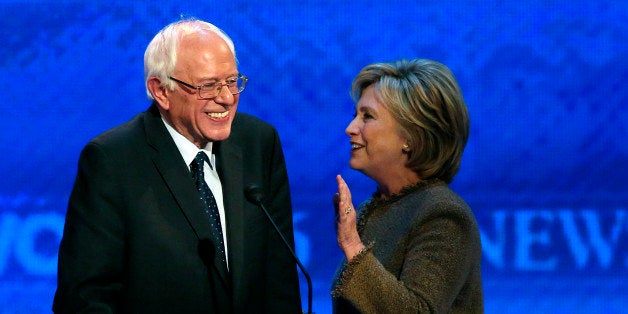 Hillary Clinton, right, speaks to Bernie Sanders during a break at the Democratic presidential primary debate Saturday, Dec. 19, 2015, at Saint Anselm College in Manchester, N.H. (AP Photo/Jim Cole)