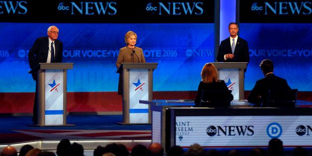 Bernie Sanders, left, Hillary Clinton, center, and Martin OâMalley take the stage for a Democratic presidential primary debate Saturday, Dec. 19, 2015, at Saint Anselm College in Manchester, N.H. Seated at the table are debate moderators Martha Raddatz, left, and David Muir, of ABC News. (AP Photo/Jim Cole)