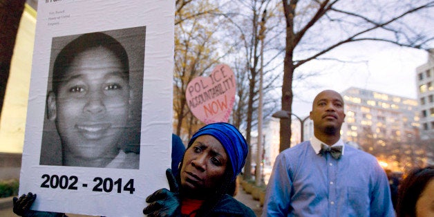 FILE - In a Monday, Dec. 1, 2014 file photo, Tomiko Shine holds up a picture of Tamir Rice, the 12 year old boy fatally shot on Nov. 22 by a rookie police officer, in Cleveland, Ohio, during a protest in response to a grand jury's decision in Ferguson, Mo. to not indict police officer Darren Wilson in the shooting death of Michael Brown, in Washington. For centuries, grand juries have held some of the criminal justice systemâs best-kept secrets. But their private process has come under extraordinary public scrutiny after high-profile decisions not to indict police officers in the deaths of unarmed men. Calls for more transparency have sounded in Congress, statehouses and editorial pages, mixed with notes of caution about forswearing secrecy that can safeguard witnesses and the accused. (AP Photo/Jose Luis Magana, File) (AP Photo/Jose Luis Magana))