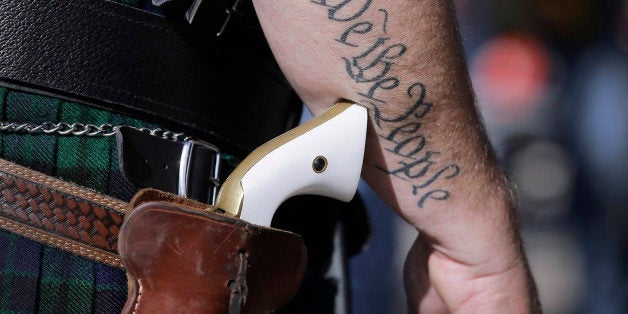 FILE - In this Jan. 26, 2015, file photo, Scott Smith, a supporter of open carry gun laws, wears a pistol as he prepares for