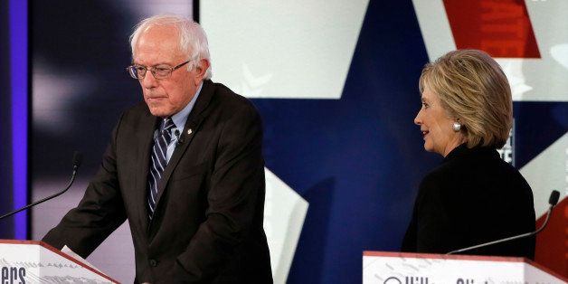 Hillary Rodham Clinton, right, walks by Bernie Sanders during a commercial break at a Democratic presidential primary debate, Saturday, Nov. 14, 2015, in Des Moines, Iowa. (AP Photo/Charlie Neibergall)