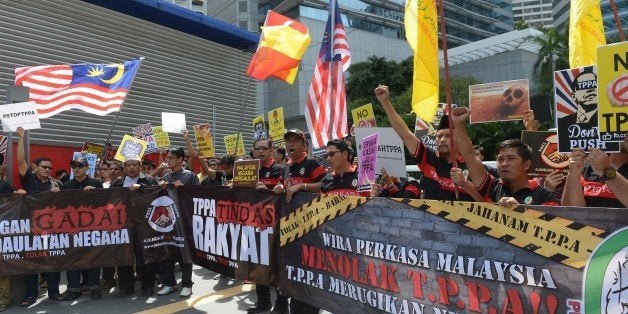 Dozens of Malaysian protesters shout slogans during a demonstration against the Trans-Pacific Partnership Agreement (TPPA), which they claim will hurt the Malaysian people, as the 27th Association of Southeast Asian Nations (ASEAN) Summit takes place in Kuala Lumpur on November 21, 2015. Malaysia is among signatories to the 12-country, US-sponsored Trans Pacific Partnership (TPP) trade deal. The twelve countries recently agreed to US President Barack Obama's Trans-Pacific Partnership (TPP) trade pact, and the US pledged to boost security assistance to its ally the Philippines, which is in a confrontation with China over maritime territory. AFP PHOTO / ADEK BERRY (Photo credit should read ADEK BERRY/AFP/Getty Images)