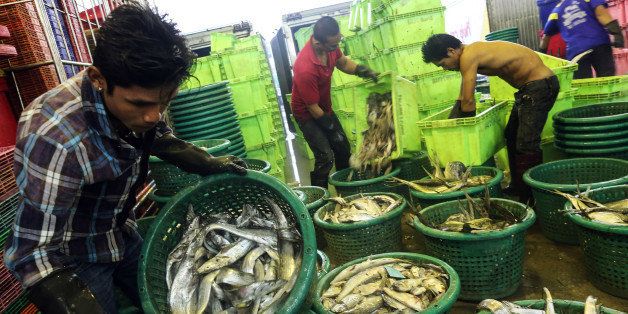 Workers unload fish into baskets for sale at the Talay Thai fish and seafood wholesale market in Mahachai, Samut Sakhon province, Thailand, on Thursday, April 23, 2015. The European Union threatened to ban imports of seafood from Thailand because of concerns about unlawful fishing, a step that would hit trade of more than 600 million euros ($641 million) a year. Photographer: Dario Pignatelli/Bloomberg via Getty Images