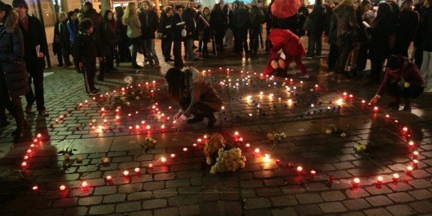 People set candles to form the word 'Peace' and in a heart shape during a demonstration to support sex workers rights on December 17, 2015 in Paris. / AFP / JACQUES DEMARTHON (Photo credit should read JACQUES DEMARTHON/AFP/Getty Images)