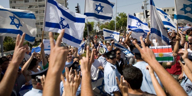 Arab Israeli students flash victory signs, foreground, as they demonstrate support for the activists aboard an aid flotilla that attempted to break the blockade on Gaza, while Israeli students hold flags demonstrating in support of Israel, outside Tel Aviv University, in Tel Aviv, Israel Wednesday, June 2, 2010. Israel on Wednesday was deporting the last of the nearly 700 foreign activists detained in a deadly raid on an aid flotilla bound for Palestinians in the blockaded, Hamas-ruled Gaza Strip. (AP Photo/Ariel Schalit)