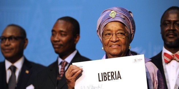 Liberian President Ellen Johnson-Sirleaf holds up an identification plaque signed by the World Trade Organisation (WTO) direc