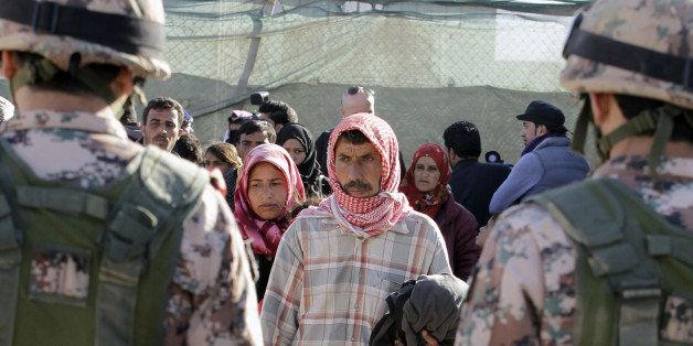 Syrian refugees cross into Jordan, at the Hadalat border crossing, east of the Jordanian capital Amman, on January 14, 2016, after being stuck between the Jordanian and Syrian borders. The number of Syrian refugees stuck on the border with Jordan has climbed from 12,000 to nearly 16,000 since December, the kingdom's government spokesman said on January 11. / AFP / KHALIL MAZRAAWI (Photo credit should read KHALIL MAZRAAWI/AFP/Getty Images)
