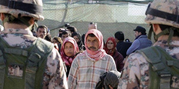 Syrian refugees cross into Jordan, at the Hadalat border crossing, east of the Jordanian capital Amman, on January 14, 2016, after being stuck between the Jordanian and Syrian borders.The number of Syrian refugees stuck on the border with Jordan has climbed from 12,000 to nearly 16,000 since December, the kingdom's government spokesman said on January 11. / AFP / KHALIL MAZRAAWI (Photo credit should read KHALIL MAZRAAWI/AFP/Getty Images)