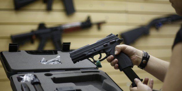A woman handles a pistol at a gun shop in Sao Caetano do Sul, Sao Paulo, Brazil on October 30, 2015. Brazil, which has one of the highest murder tolls on the planet, could soon end most restrictions on gun ownership, risking what one critic called a 'Wild West' scenario. A draft law stripping away current limits has already been approved in committee and is due to go to the lower house of Congress in November. AFP PHOTO / Miguel SCHINCARIOL (Photo credit should read Miguel Schincariol/AFP/Getty Images)