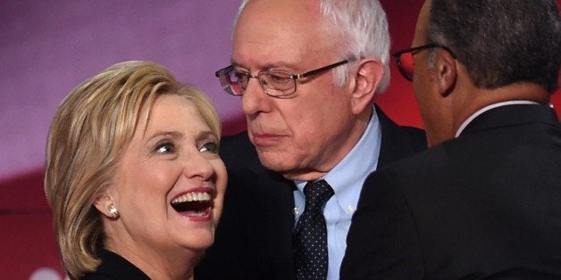 Democratic presidential candidates Hillary Clinton (L) and Bernie Sanders (R) confer during the NBC News -YouTube Democratic