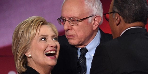 Democratic presidential candidates Hillary Clinton (L) and Bernie Sanders (R) confer during the NBC News -YouTube Democratic Candidates Debate on January 17, 2016 at the Gaillard Center in Charleston, South Carolina. / AFP / TIMOTHY A. CLARY (Photo credit should read TIMOTHY A. CLARY/AFP/Getty Images)