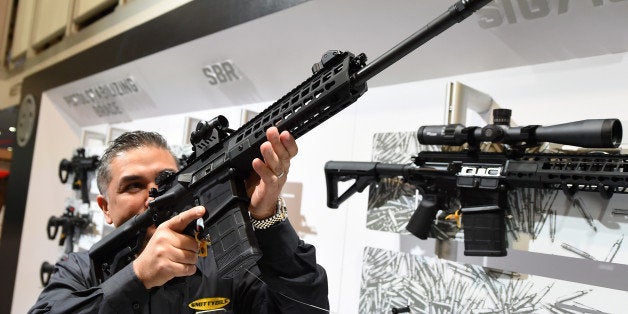 LAS VEGAS, NV - JANUARY 19: Glen Kukula checks out a Patrol SIG716 rifle by Sig Sauer at the 2016 National Shooting Sports F