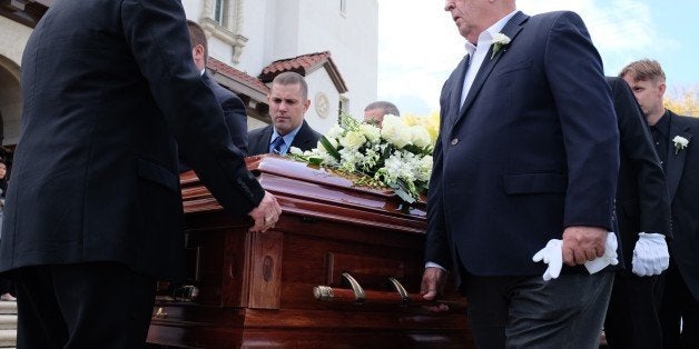 Pallbearers carry the casket of 58-year-old San Bernardino shooting victim Damian Meins on December 11, 2015 in San Bernardino, California. Meins was at the training and holiday luncheon at the Inland Regional Center when Syed Farook and his wife, Tashfeen Malik, barged in on the gathering and opened fire on his San Bernardino County Department of Public Health coworkers, killing 14 and injuring 22 others in what the FBI is investigating as an 'act of terrorism.' AFP PHOTO /GUILLAUME MEYER / AFP / Guillaume Meyer (Photo credit should read GUILLAUME MEYER/AFP/Getty Images)