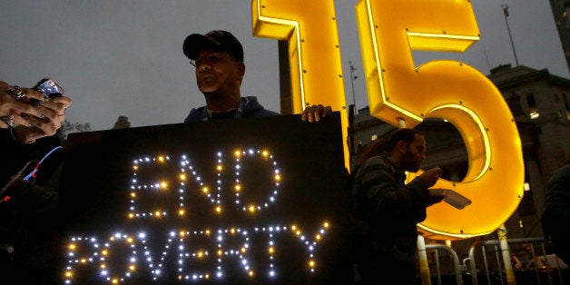 A demonstrator holds a sign during a home care and healthcare workers rally for $15 minimum wage, Tuesday, Nov. 10, 2015, in New York. New York Gov. Andrew Cuomo is raising the minimum wage for about 10,000 state workers to $15 an hour over the next six years. (AP Photo/Mary Altaffer)