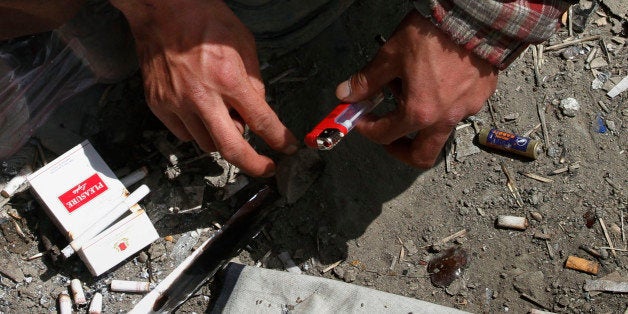 An Afghan holds his lighter as he prepares to smoke drugs in Kabul, Afghanistan, Friday, March 12, 2010. Though the majority