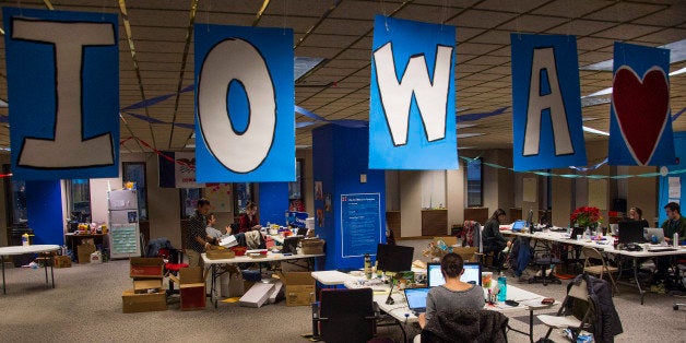 Banners spelling out Iowa hang from the ceiling as volunteers work at the Hillary for Iowa Campaign Headquarters in Des Moine
