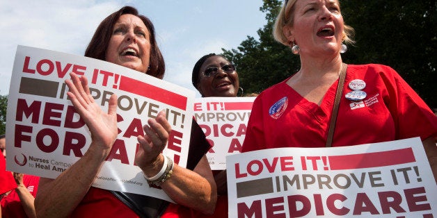 Nurses, from left, Katie Murphy of Boston, Kimberly Wallace of Buffalo, N.Y., and Nora Watts of Westborough, Mass., participate in a rally on Capitol Hill in Washington, Thursday, July 30, 2015, in support of Medicare on the 50th anniversary of Medicare and Medicaid. (AP Photo/Jacquelyn Martin)