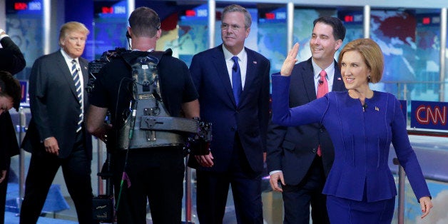 Republican presidential candidate, businesswoman Carly Fiorina, right, leads fellow candidates Scott Walker, second from right, Jeb Bush, center, and Donald Trump as they take the stage prior to the CNN Republican presidential debate at the Ronald Reagan Presidential Library and Museum on Wednesday, Sept. 16, 2015, in Simi Valley, Calif. (AP Photo/Chris Carlson)