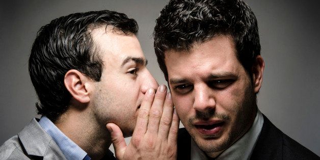 image of a young professional whispering to another