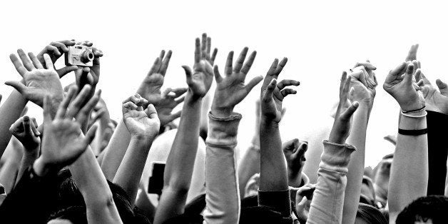 Concert excitement, evident in the raised hands of youth.