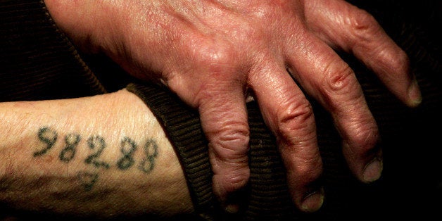 LONDON - DECEMBER 9: Auschwitz survivor Mr. Leon Greenman, prison number 98288, displays his number tattoo on December 9, 2004 at the Jewish Museum in London, England. Mr. Greenman O.B.E age 93 and a British citizen, spent three years of his life in six different concentration camps during World War II and since 1946 he has tirelessly recounted his life through his personal exhibition at the museum where he conducts educational events to all age groups. January 2005 will be the 60th anniversary of the liberation of the extermination and concentration camps, when survivors and victims who suffered as a result of the Holocaust will commemorated across the world. (Photo by Ian Waldie/Getty Images)