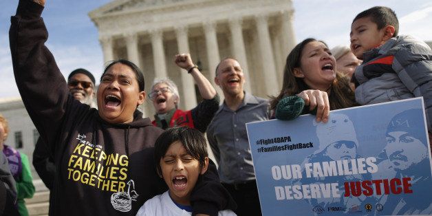 WASHINGTON, DC - DECEMBER 11: Rosario Reyes (L), 36, and her son Victor Reyes, 7, chant 'Si se puede!' during a prayer for justice vigil and rally in front of the Supreme Court December 11, 2015 in Washington, DC. Organized by The Fair Immigration Reform Movement (FIRM) and CASA, about 40 people gathered to pray for the Supreme Court justices after they agreed to hear a case regarding President Barack Obama's executive order to expand Deferred Action for Childhood Arrivals and implement Deferred Action for Parental Accountability. (Photo by Chip Somodevilla/Getty Images)