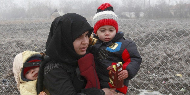 A Syrian refugee woman with babies walks towards the border with Serbia from the transit center for refugees near northern Macedonian village of Tabanovce, while on their journey through the so-called Balkan migrant corridor, Thursday, Jan. 28, 2016. Greek authorities say neighboring Macedonia has stopped Wednesday letting in refugees heading north to central Europe, leaving about 2,600 people stranded on the Greek side of the border. (AP Photo/Boris Grdanoski)