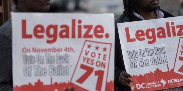 People hold signs for Ballot Initiative #71, the legalization of marijuana, on November 4, 2014 in Washington, DC. Voters aro