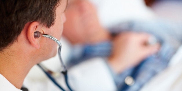 Doctor examining a patients heart beat with a stethoscope