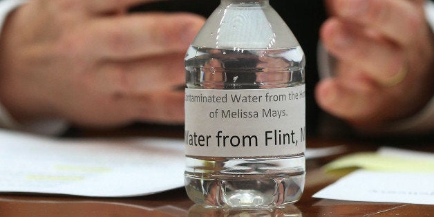 WASHINGTON, DC - FEBRUARY 03: A bottle of contaminated Flint tap water sits on the witness table while Rep. Dan Kildee (D-MI