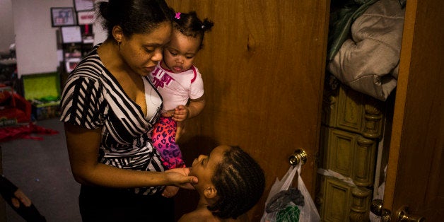 FLINT, MICHIGAN - FEBRUARY 4: Brittny (correct sp) Giles, of Flint, Mich., disciplines her son Joshua, 5, for using an inappropriate phrase while holding her 9-month-old daughter, Joel, at their home in Flint, Mich., on Thursday, February 4, 2016. Giles recently had her children's blood lead levels tested which came back low, but she said she is still concerned because the children have almost always consumed bottled water. She now questions whether or not she wants to continue living in the city of Flint. 'I want to stay in Flint, because I was born and raised in Flint, but if I have to move to better my family, I will,' Giles said. 'It's just really sad. Flint used to be General Motors. It was fun, but now it's just abandoned houses and water bottles.' (Photo by Brittany Greeson for The Washington Post via Getty Images)