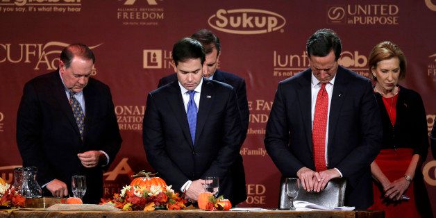 Republican presidential candidates, from left, former Arkansas Gov. Mike Huckabee, Sen. Marco Rubio, R-Fla., former Pennsylvania Sen. Rick Santorum and Carly Fiorina bow their heads in prayer at the end of the Presidential Family Forum, Friday, Nov. 20, 2015, in Des Moines, Iowa. (AP Photo/Charlie Neibergall)