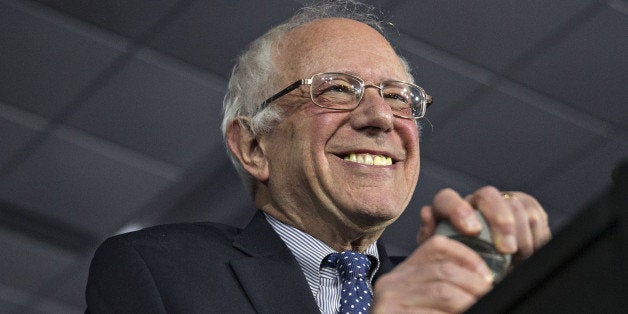 Senator Bernie Sanders, an independent from Vermont and 2016 Democratic presidential candidate, smiles as he arrives to speak during a caucus night party in Des Moines, Iowa, U.S., on Monday, Feb. 1, 2016. Hillary Clinton is clinging to the narrowest edge over Sanders in the Iowa caucuses. Photographer: Andrew Harrer/Bloomberg via Getty Images 